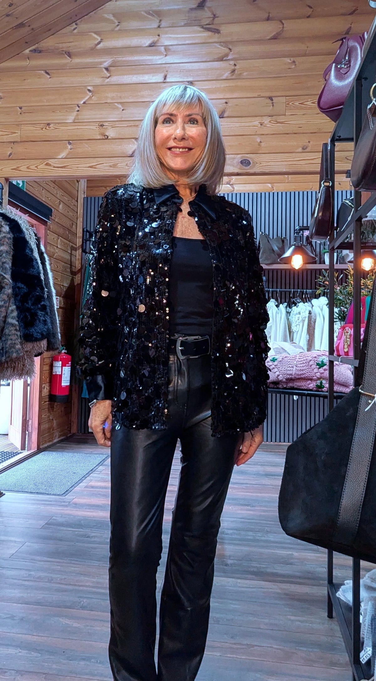 Di wearing the Shania black sequin blouse open over a black top and trousers.