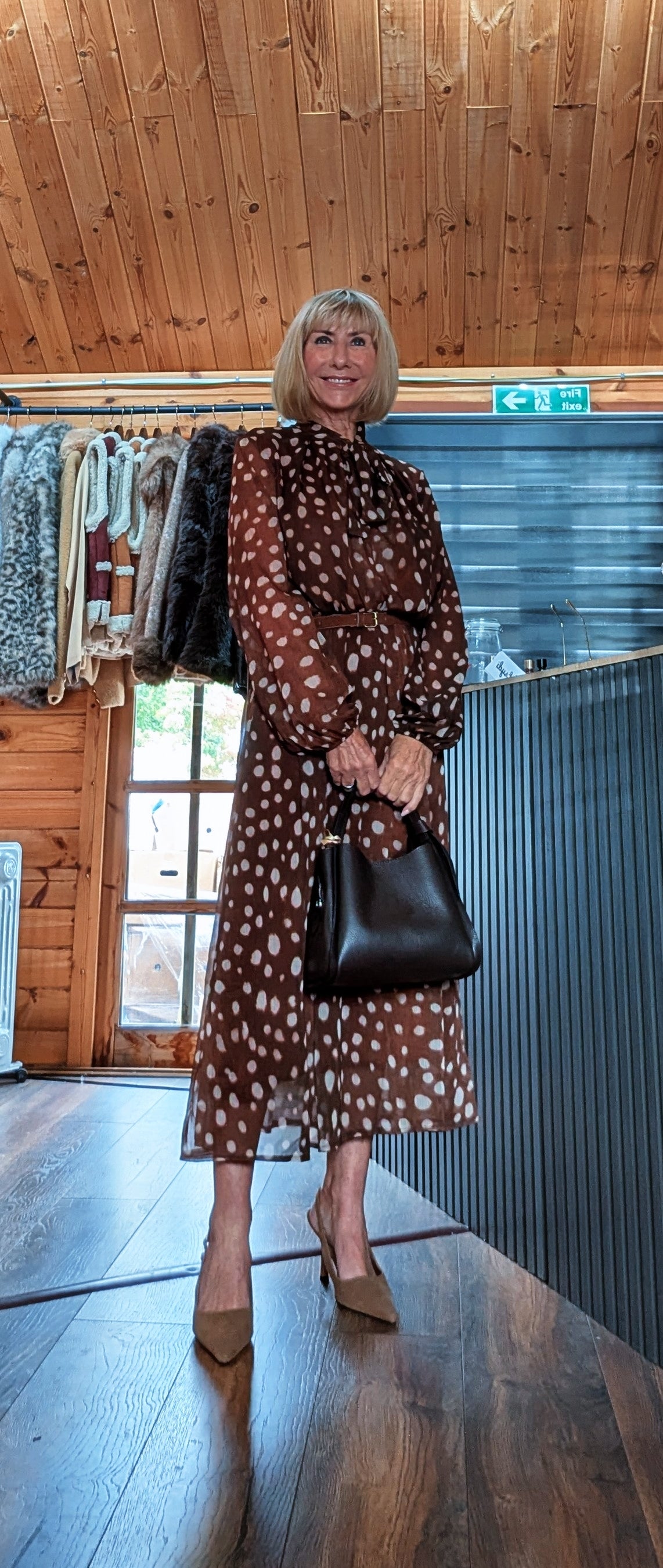 Dorothy chocolate midi dress styled with neutral heels and a black handbag held in front