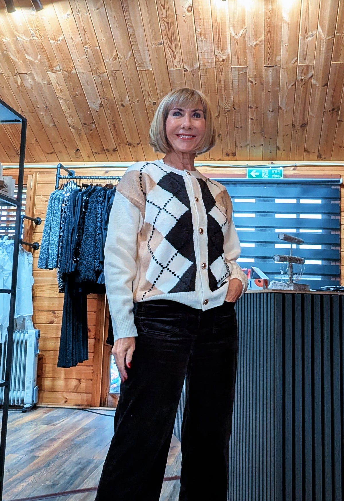 Closer view of the Irene cardigan, showing black and beige argyle diamonds and button fastening