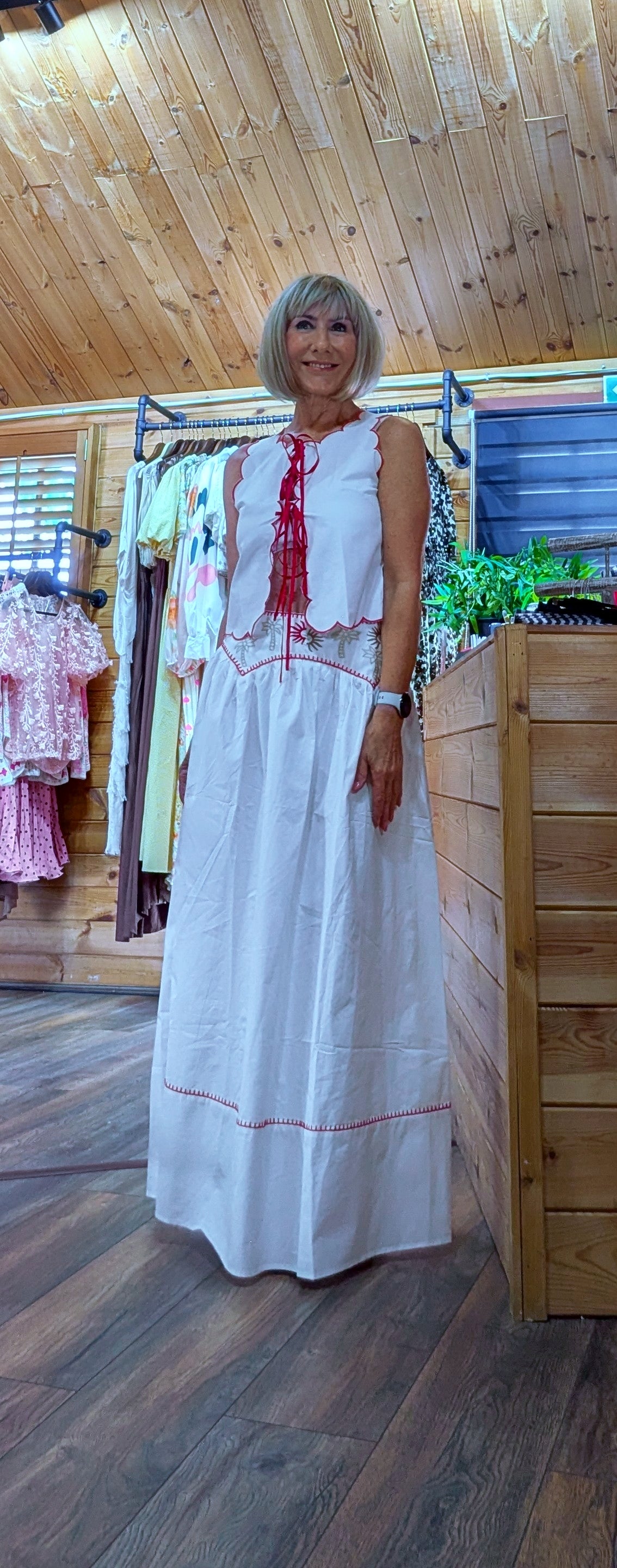 Model wearing the Iris white cotton top and skirt co-ord, a lightweight embroidered two-piece outfit perfect for holidays, garden parties and summer occasions.