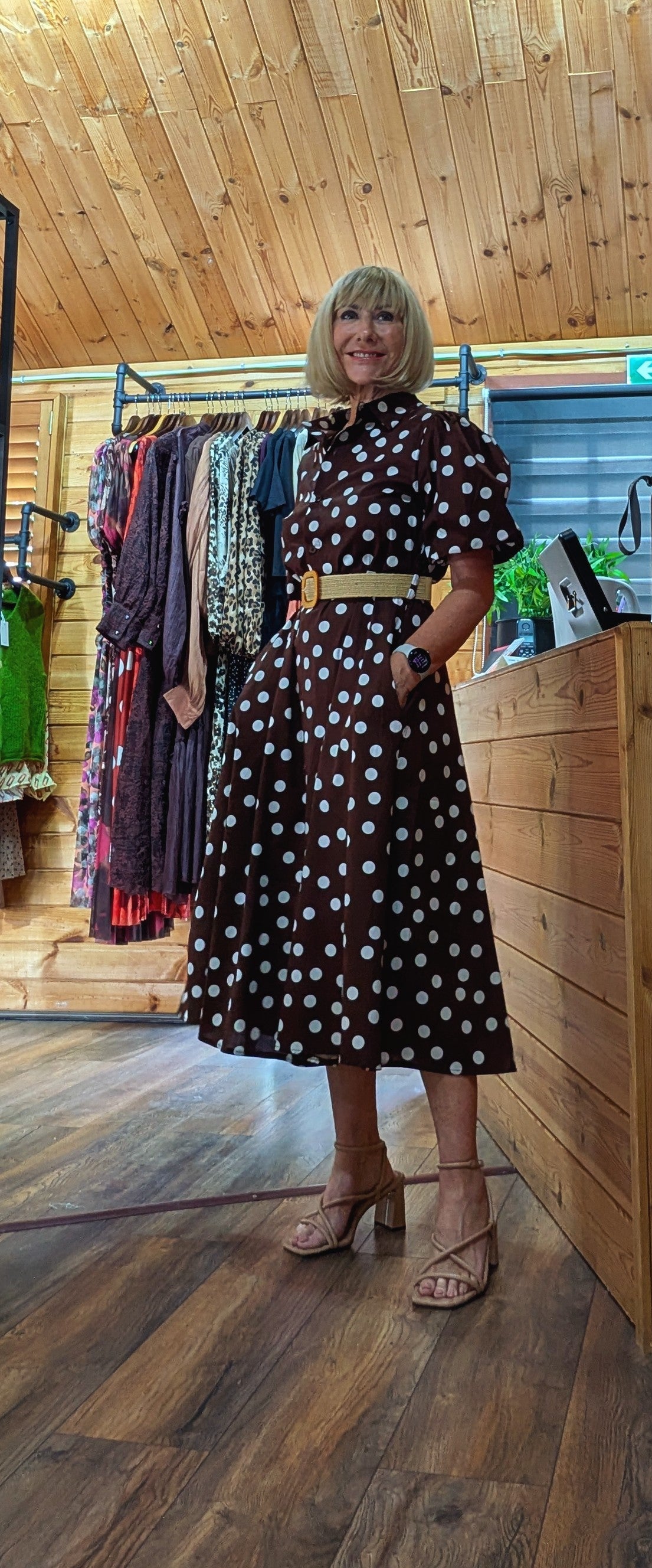 Full-length view of the Aoife brown occasion dress with white spots and short sleeves.