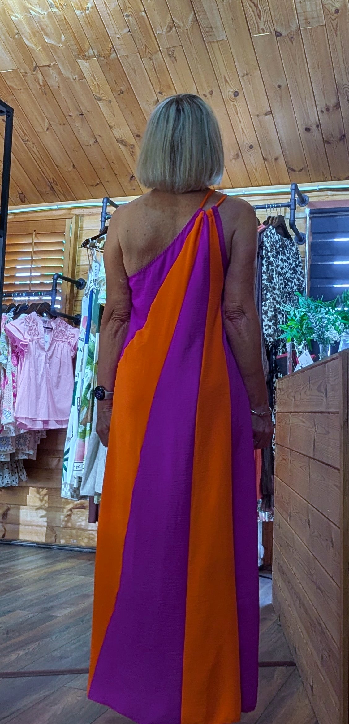 Rear view of Tate occasion dress with one shoulder in magenta and orange