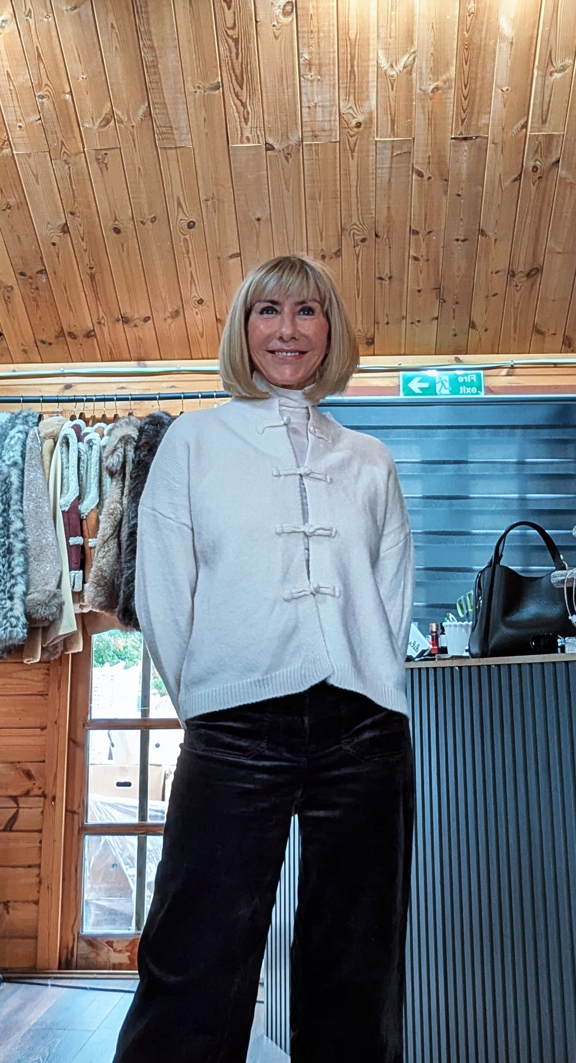 Closer view of Fran cardigan showing the round neckline and matching cream knot fastenings