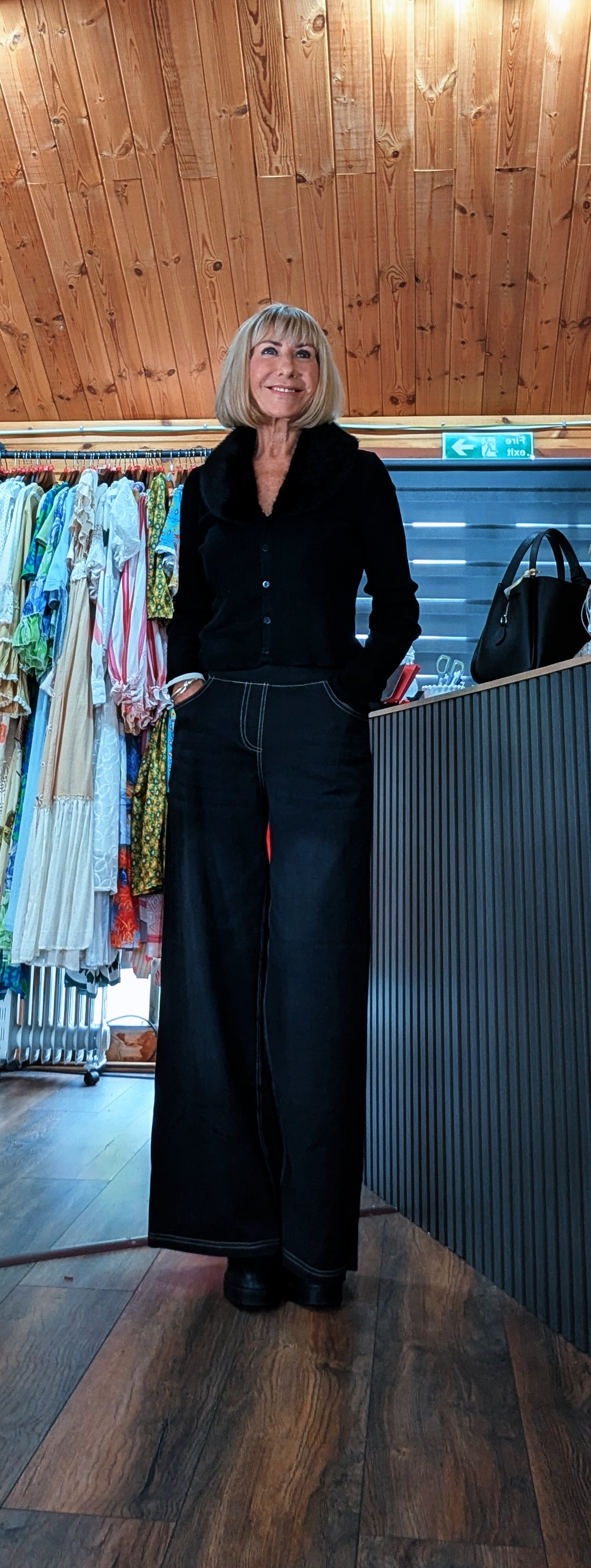 Women’s black wide leg jeans with contrast stitching worn with Arabella blacl cardigan with faux fur neck