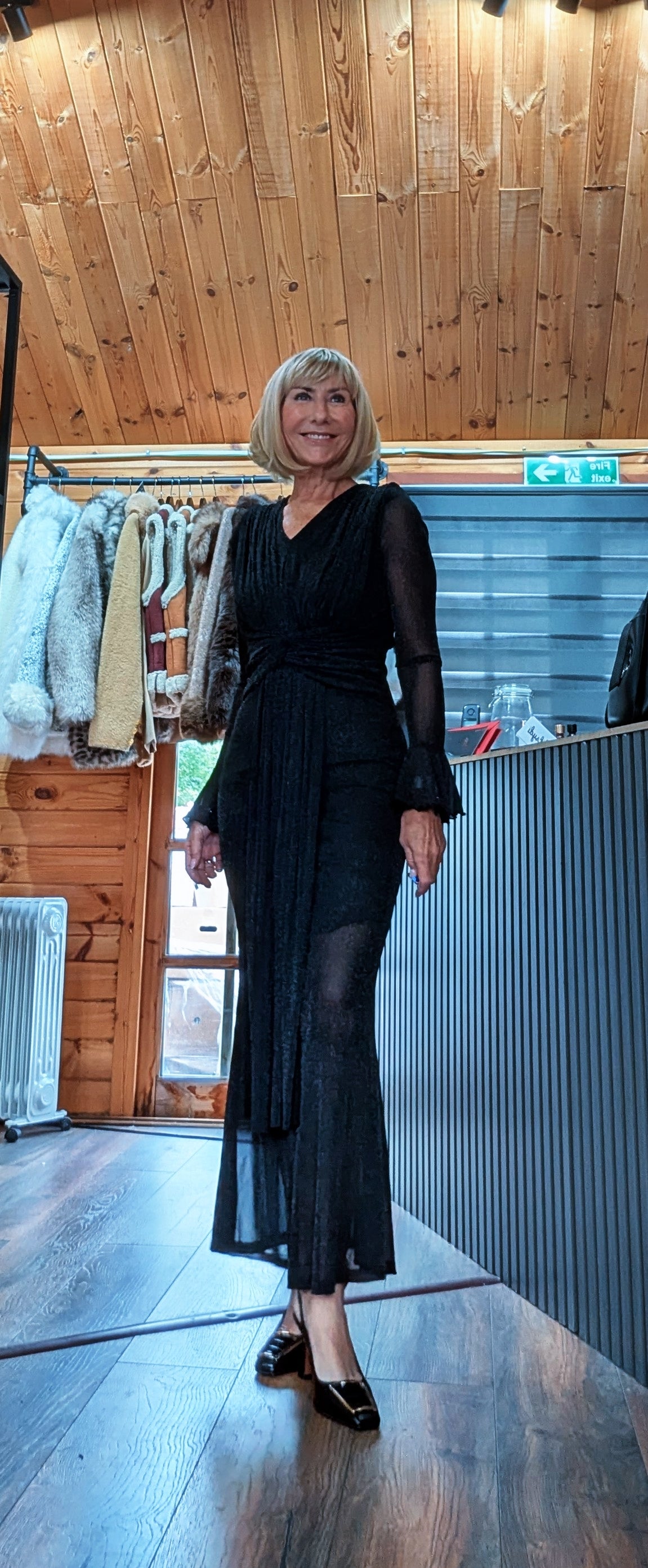 Shirley long-sleeved black dress modelled from the front with a sheer mesh hem